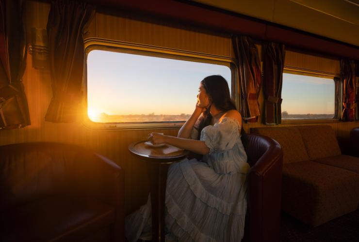 一位女士在“甘号”列车上品尝热饮 © 北领地旅游局/Daniel Tran 版权所有