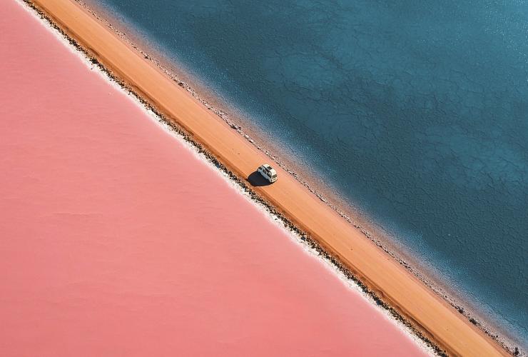 南澳大利亚州，艾尔半岛，一辆面包车行驶在粉色麦克唐奈尔湖与格林湖之间土路上的鸟瞰图 © Lyndon O′Keefe 版权所有
