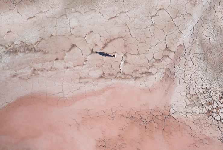 南澳大利亚州，艾尔半岛，人们站在粉色麦克唐奈尔湖干涸的湖边并在地上投下影子的鸟瞰图 © 澳大利亚旅游局版权所有